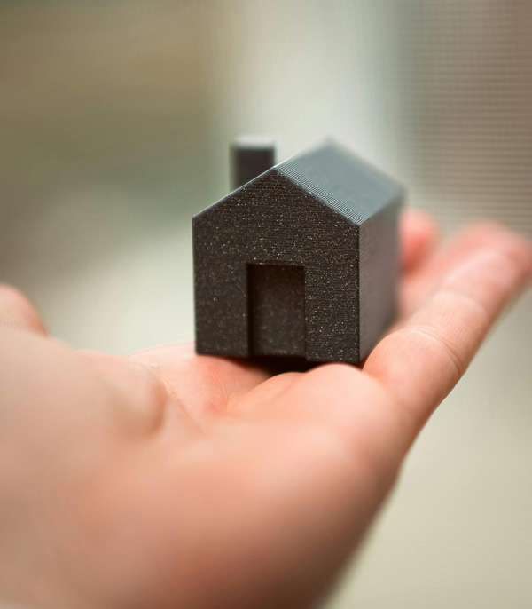 Hand Holding Small Model House Symbolizing Real Estate